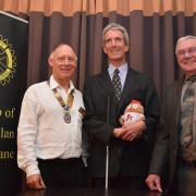 Ken Reid (centre) holding Haggeye (his mascot on the journey) with president Nick Rawlings (left) and speaker’s host Glen Montgomery