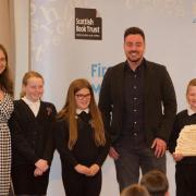 Author Ross MacKenzie presents the School Reading Journey Award, which was accepted by class teacher Donna Bullivant and pupils Chloe, Ramsay and Tyler – Picture courtesy of Rob McDougall