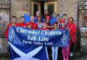 The children hold aloft a Scotland flag