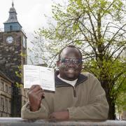 Salah Komi, pictured with his first-ever poll card, is excited to be able to vote today